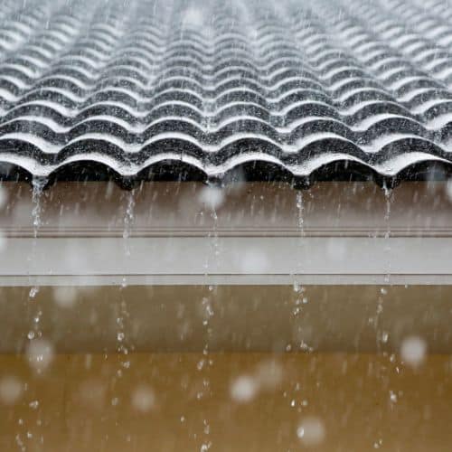 Rain drops falling on roof shingles with waterproofing