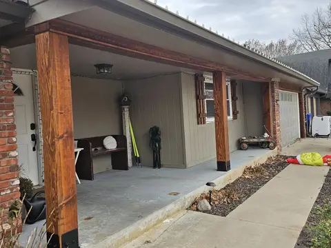 Brick home exterior with new white windows and a concrete patio