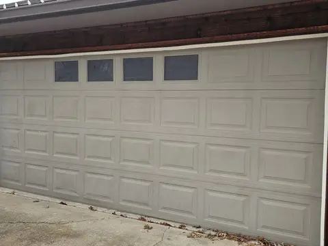 New white garage door on a brick home with white trim
