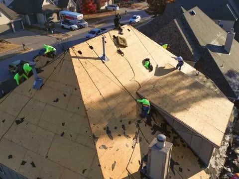 Roofing crew installing underlayment on a large residential roof
