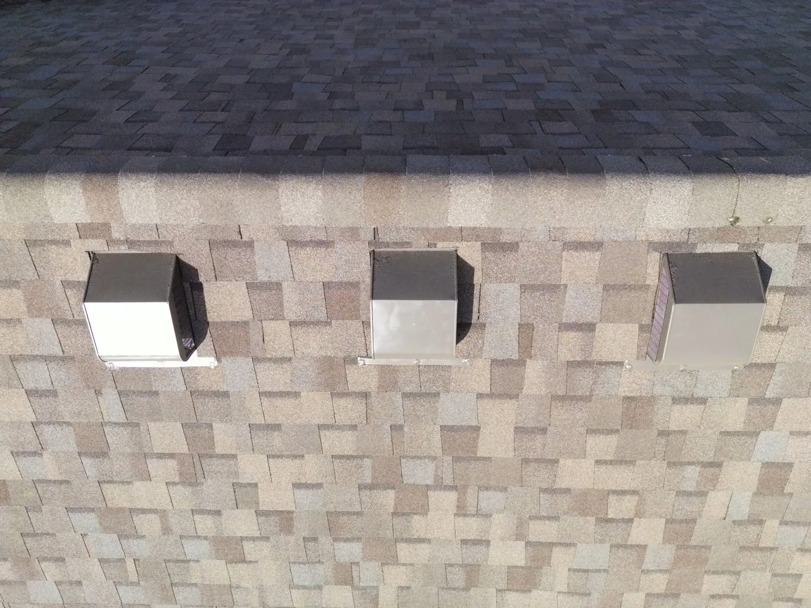 Three roof vents are visible on a shingled roof.