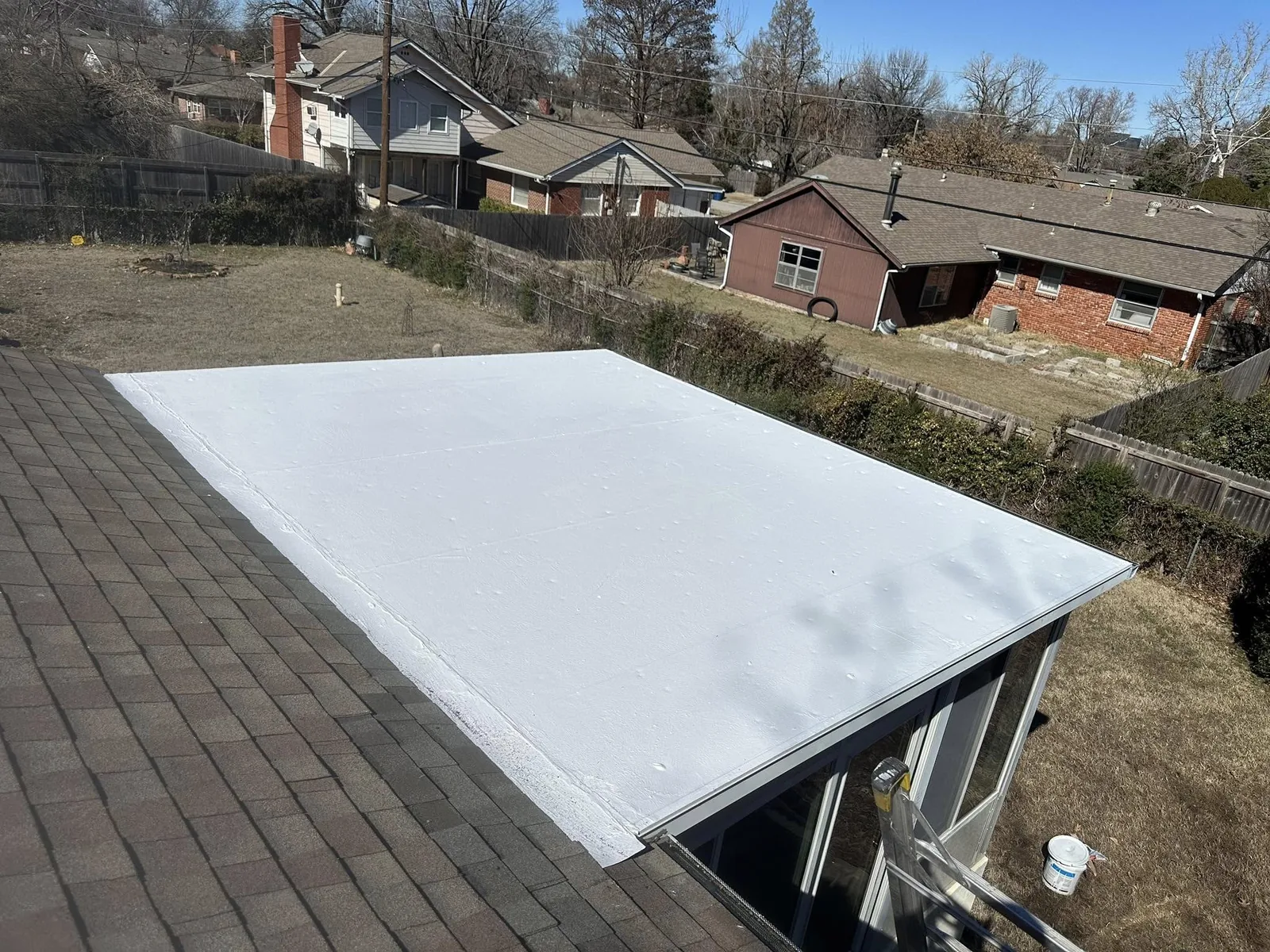 A newly installed white flat roof on a residential building.