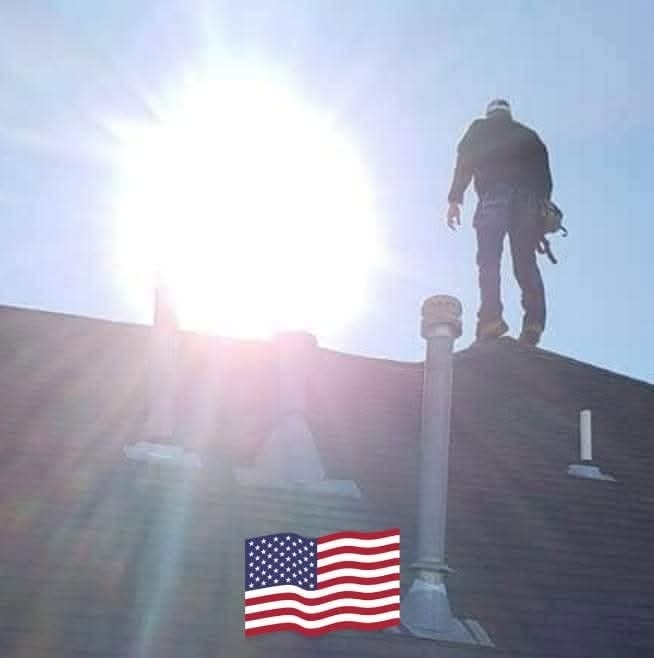 A roofer stands on a roof under a bright sun, with an American flag in the foreground.