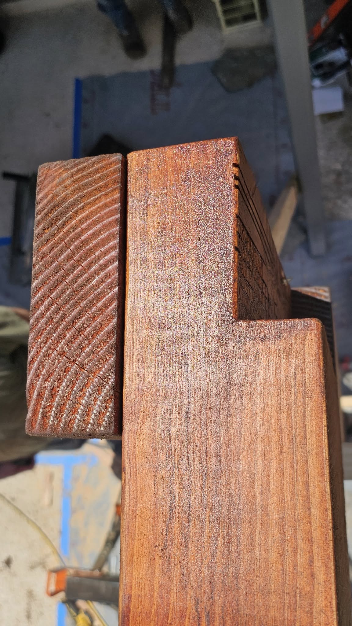 Two stained wooden beams are shown outdoors.