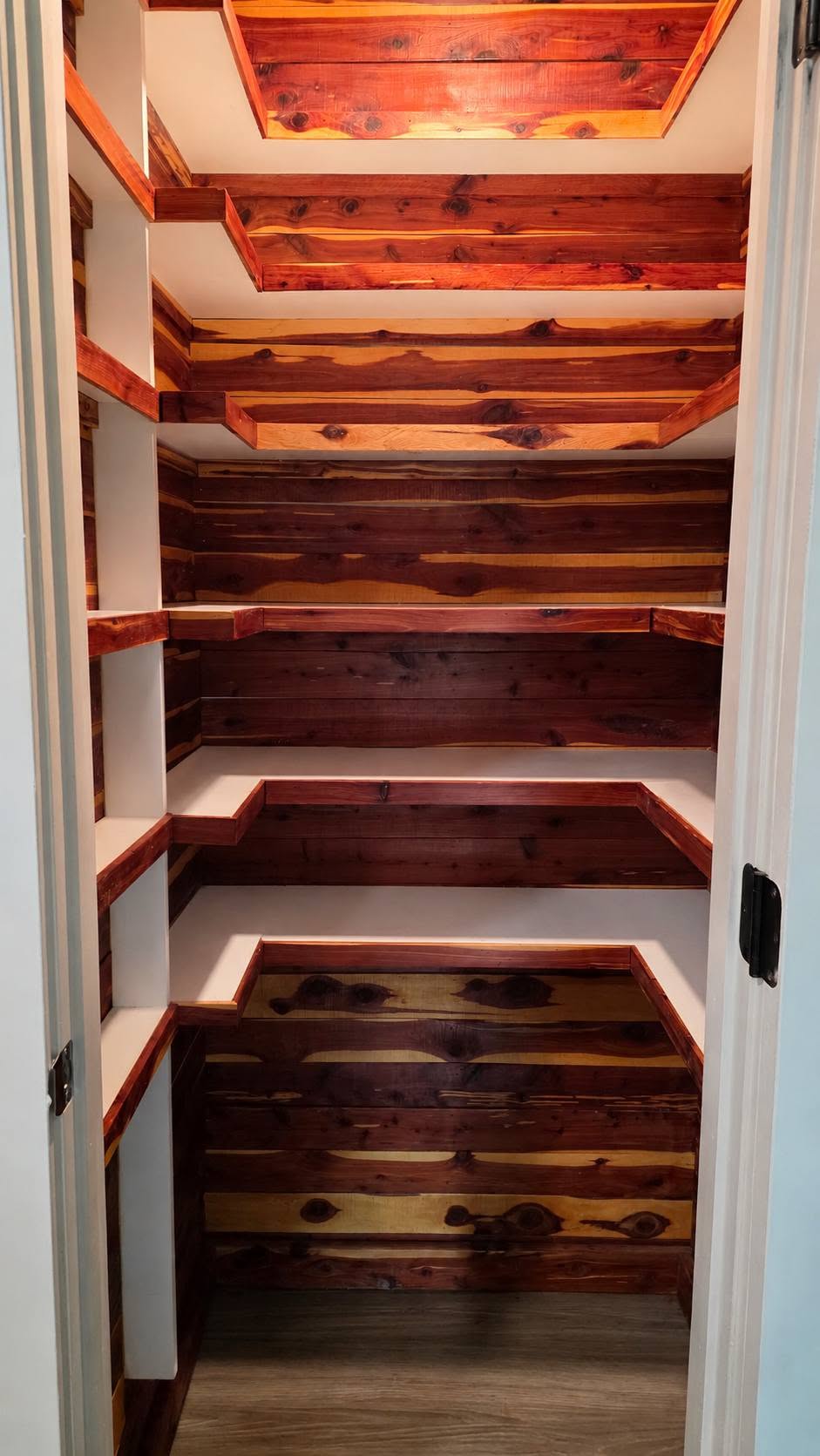 A walk-in closet with cedar-lined shelves and walls.